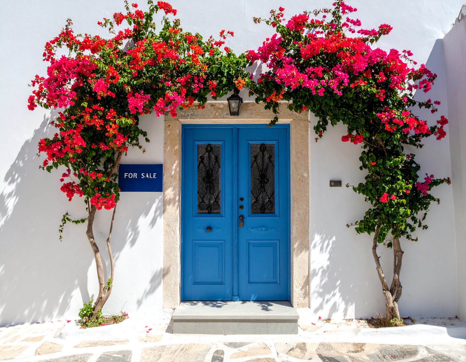 A welcoming shot of a traditional Corfiot house doorway with vibrant bougainvillea
